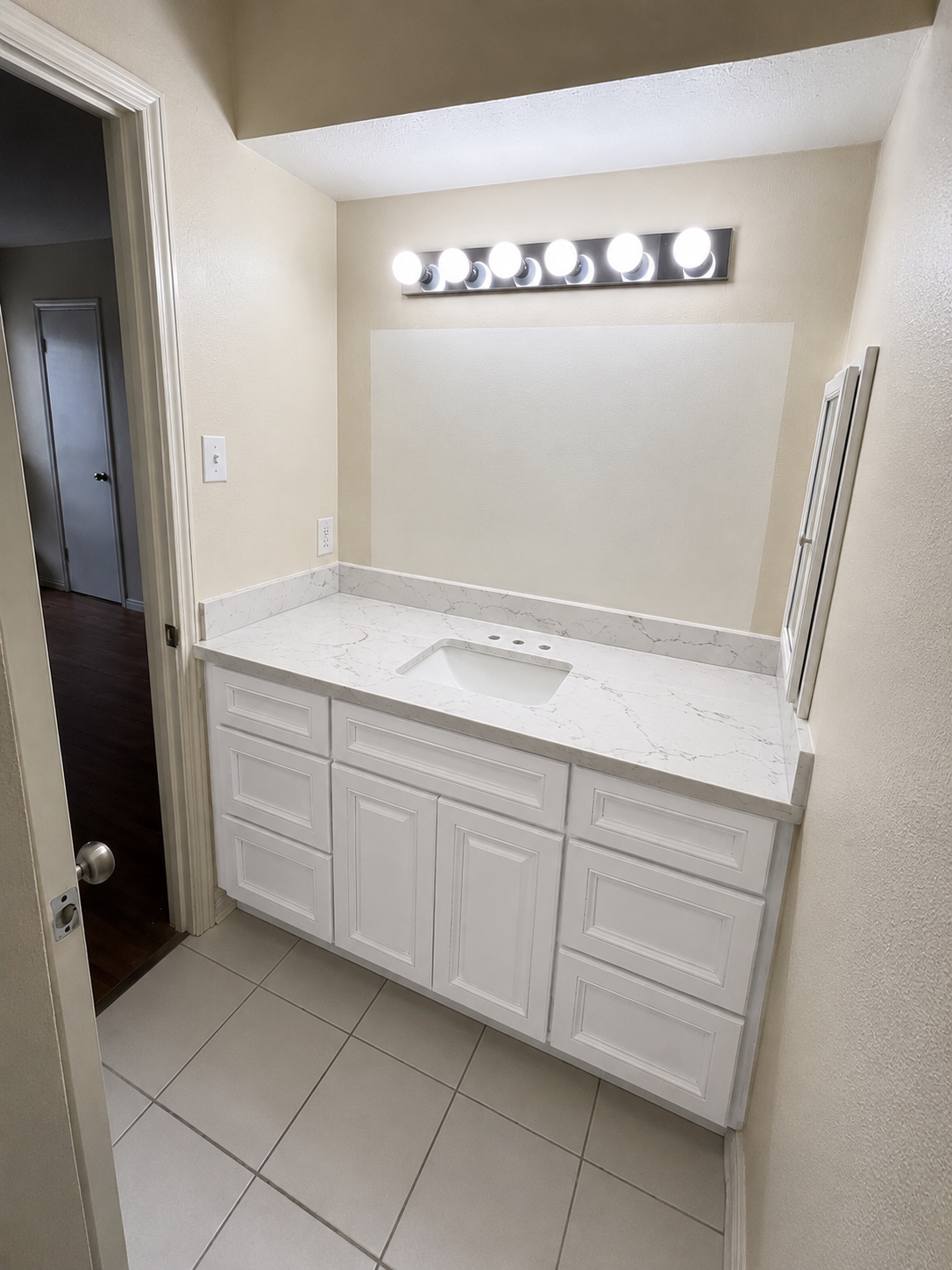 White vanity cabinet with marble-look quartz countertop and undermount sink