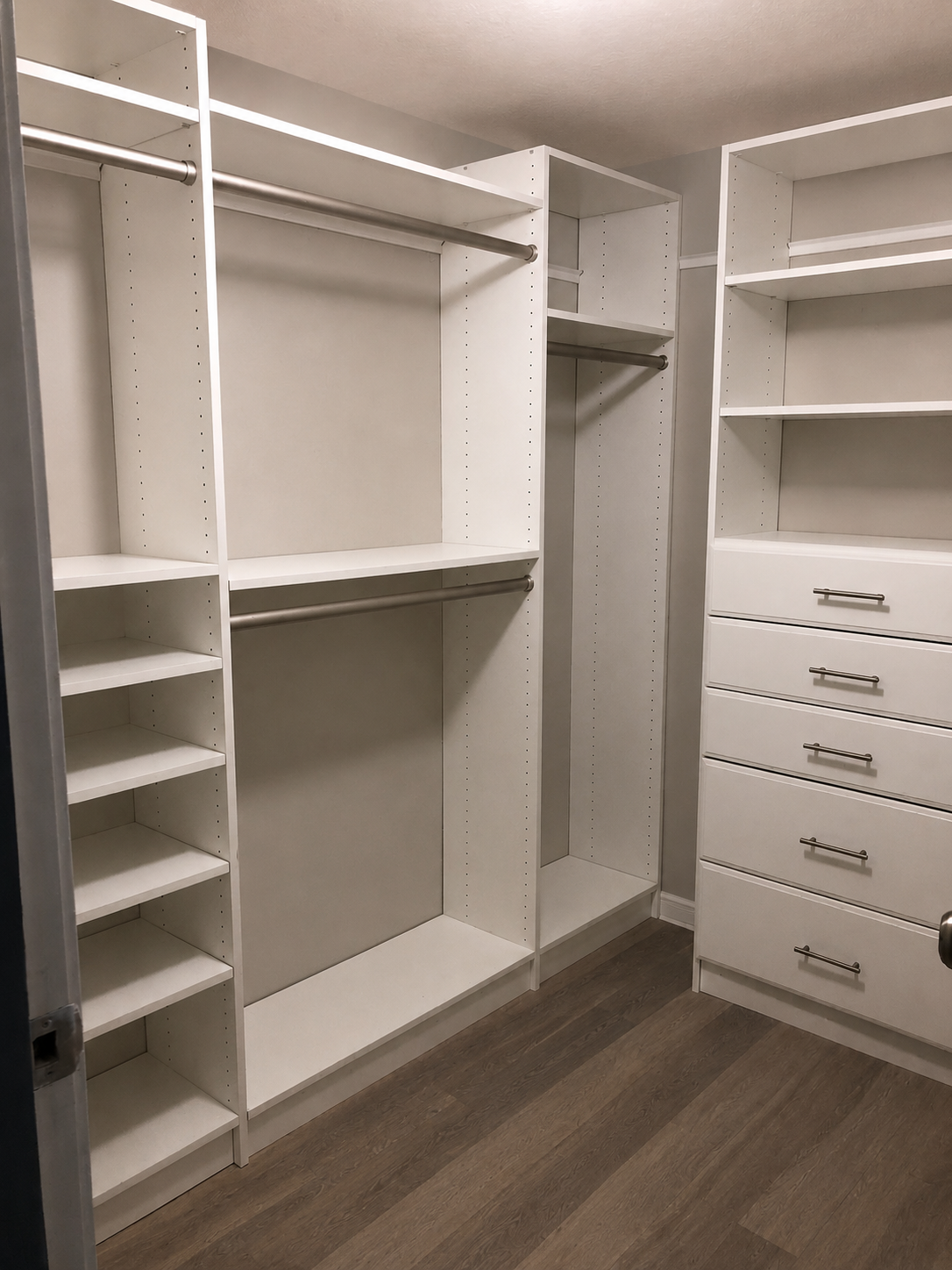 Large white walk-in closet with shoe shelving, drawers, and double hanging rods