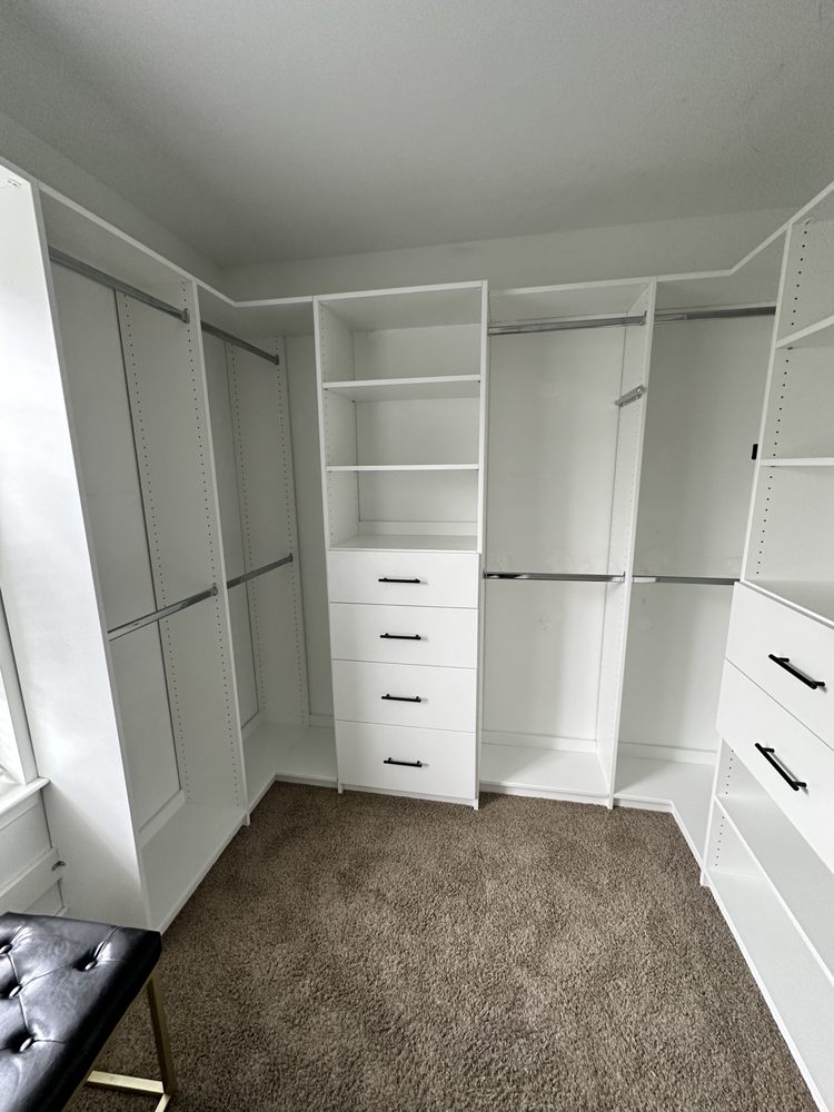 White corner walk-in closet system with hanging rods, shelves, and drawers